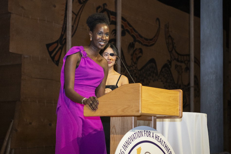 Two students on a stage presenting an award.