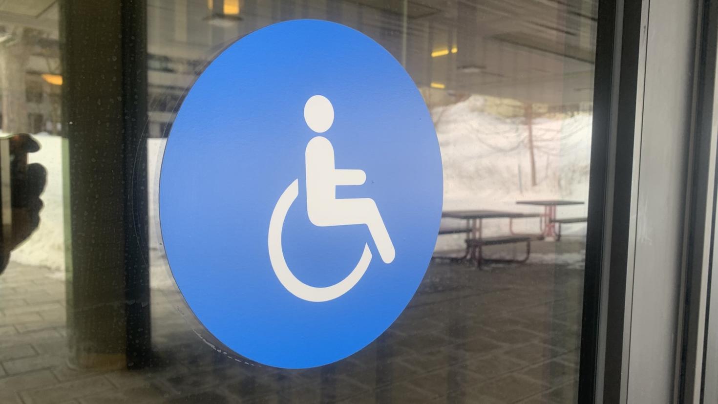  A wheelchair sign on a door indicating a uOttawa campus building is accessible.
