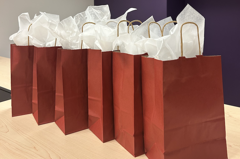 Six red gift bags on a table