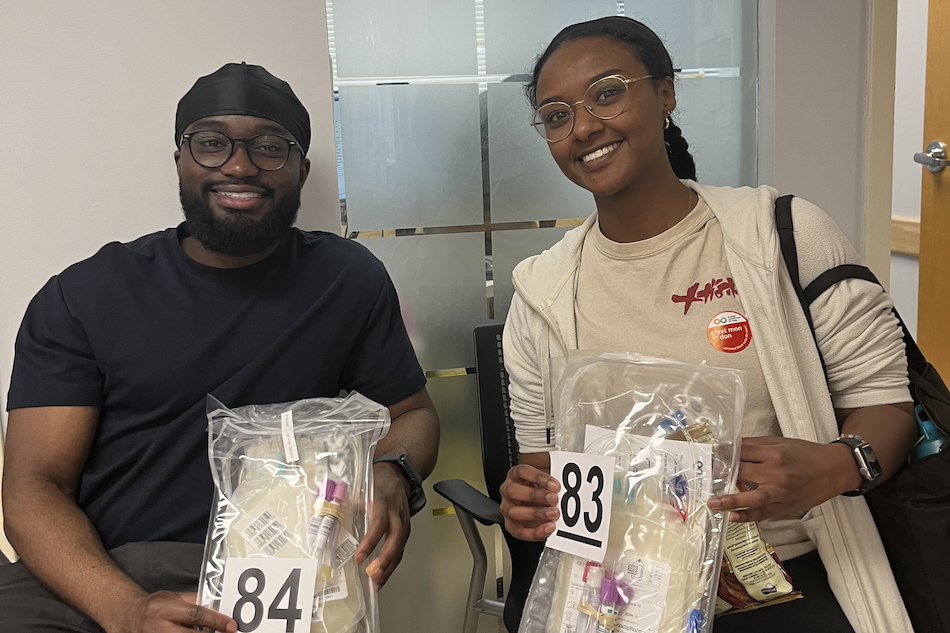 Two people with their donation kits as they await their turn to give blood