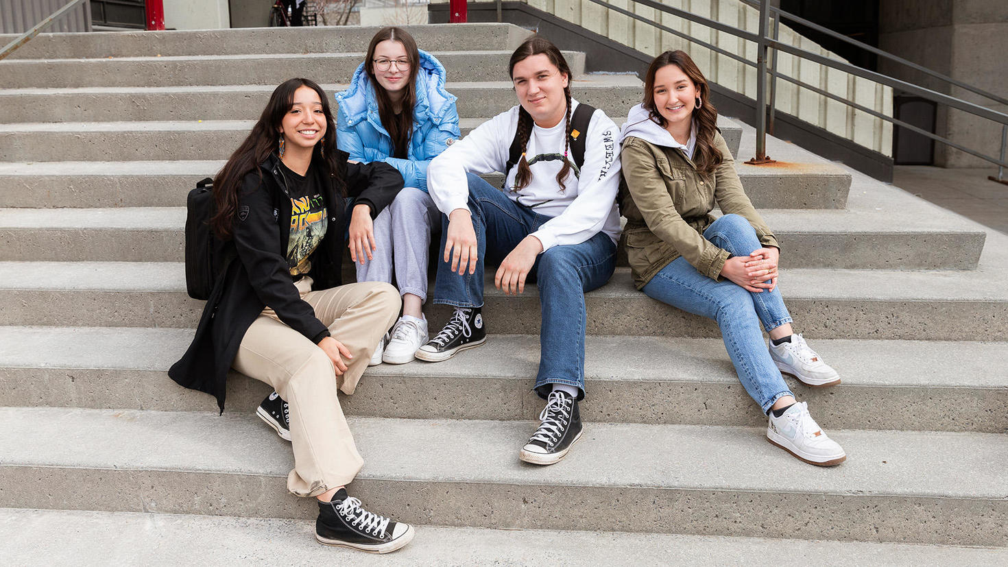 Indigenous students sitting outside, on campus.