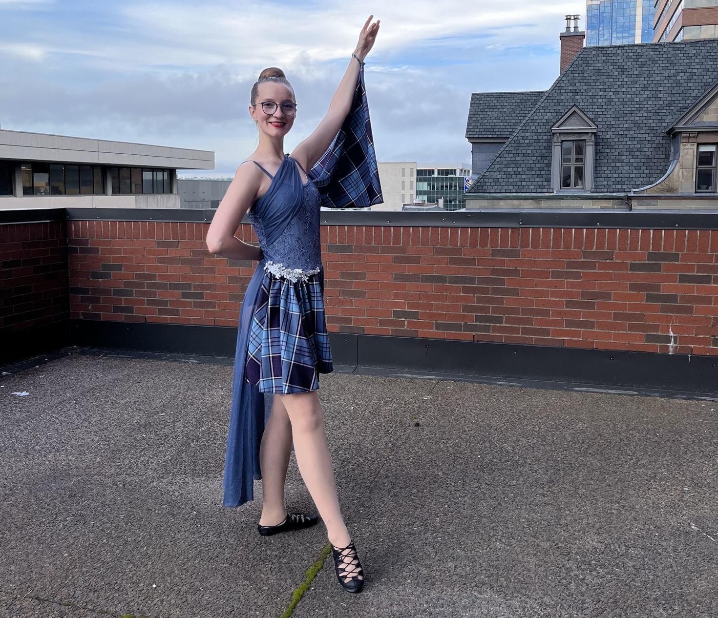 Laura Maddison wearing her highland dancer outfit while posing on a rooftop
