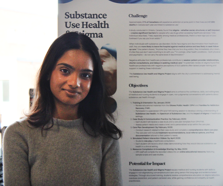 The winner for top project from the University of Ottawa stands beside their poster.