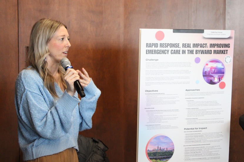 A person presents a research poster to an audience