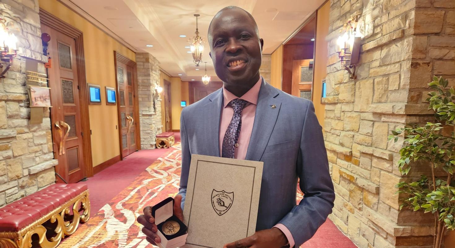 Professor Mamadou Fall holding the John B. Stirling Medal.