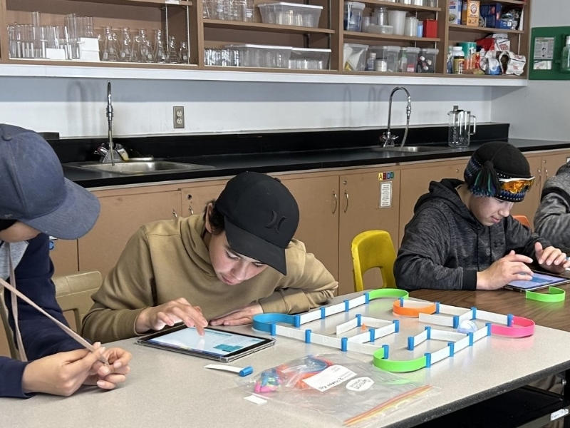 Three kids in an engineering workshop.