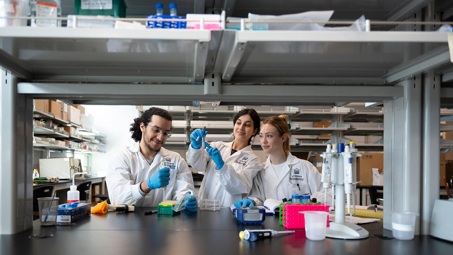 Three students making experiments in a lab