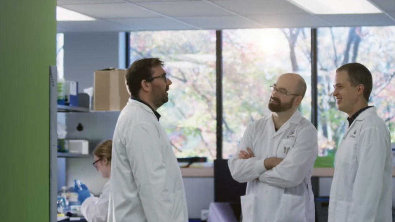 Three male professors talking in a lab