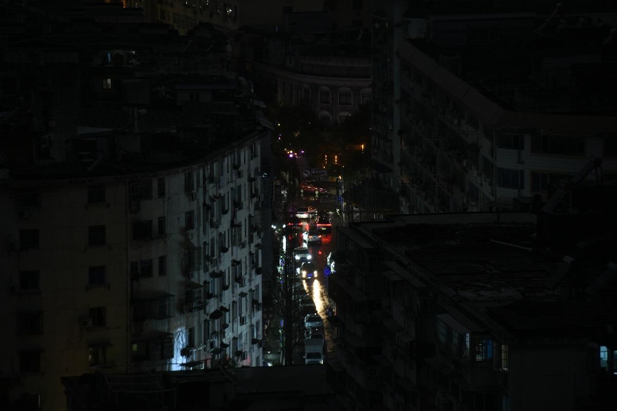 Des voitures roulent dans une ville plongée dans le noir