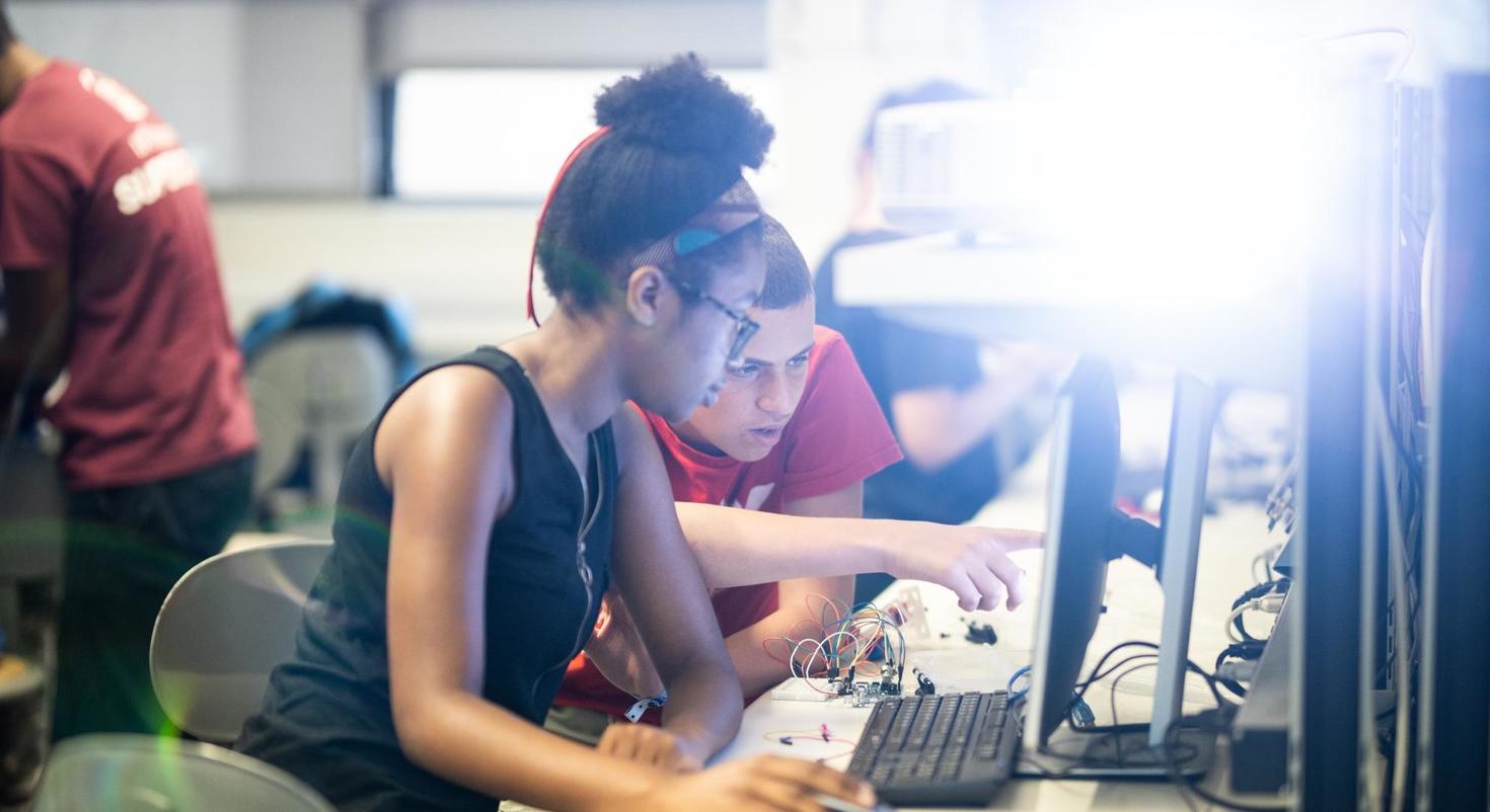 Two teenagers using a computer.