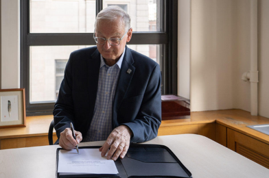 President Jacques Fremont signs Scarborough charter at desk in office