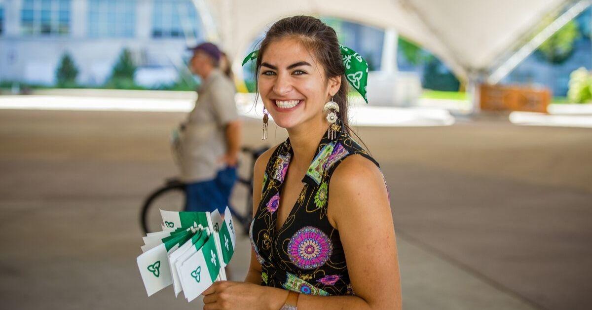 Un étudiante tient des drapeaux franco-ontariens.