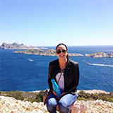 caitrd sitting on rocks in front of the ocean on a sunny day