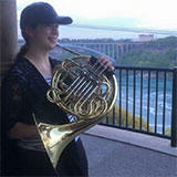 chantalprousse by a river holding a French horn