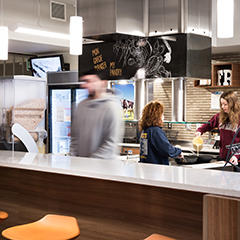 Three students focus on cooking a meal.