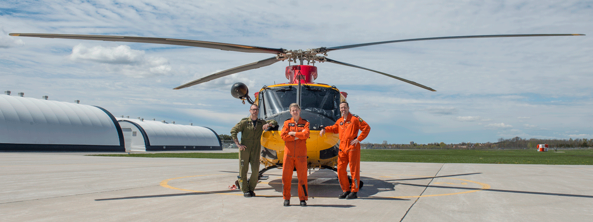 Crivicich and his team stand in front of helicopter