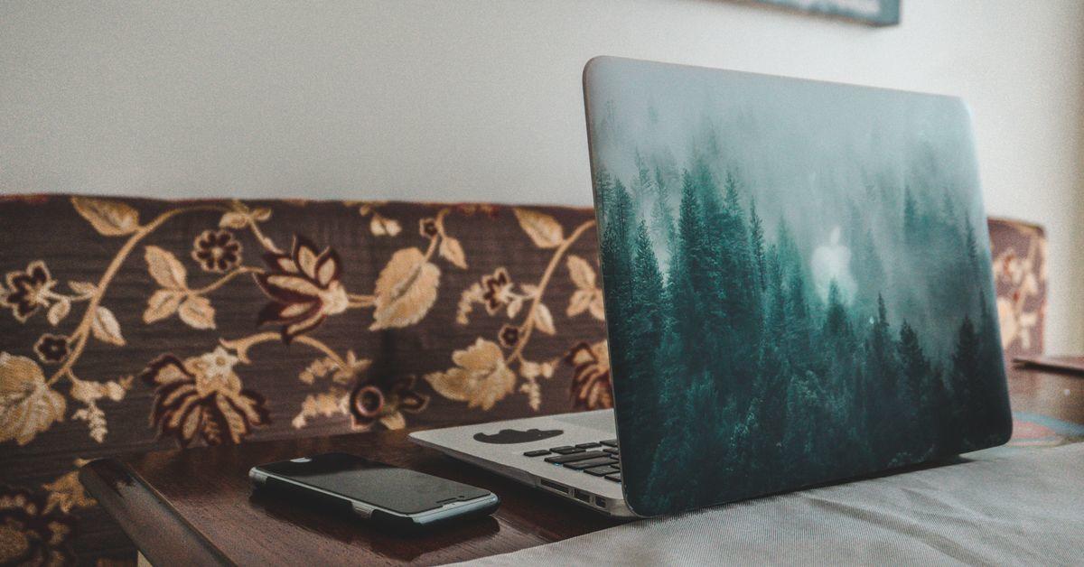 Un ordinateur portable ouvert est posé sur une table de salle à dîner.
