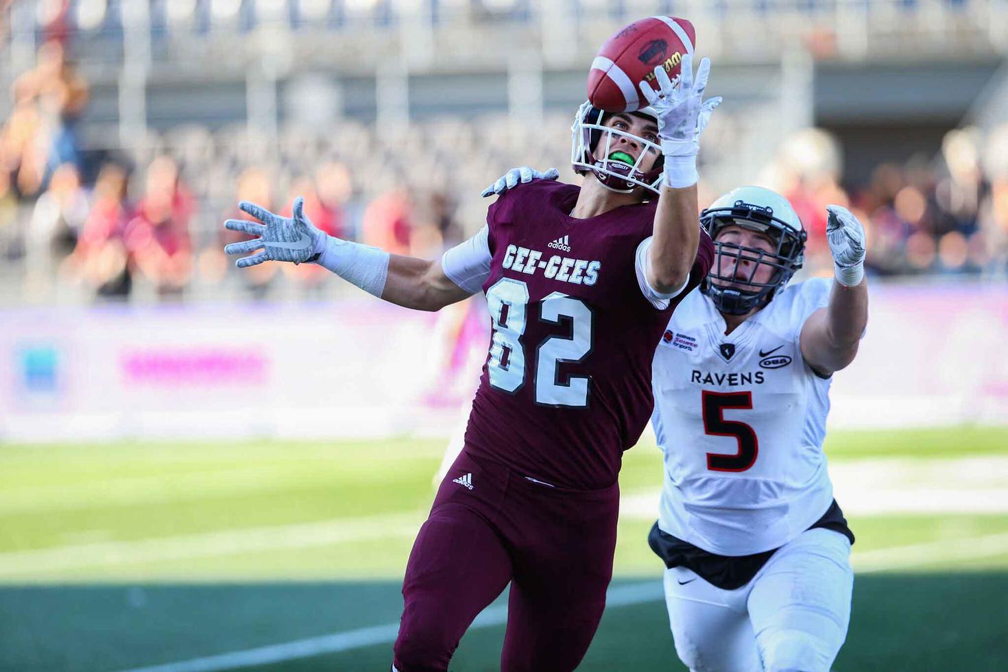 uOttawa football player catches the ball with one hand.