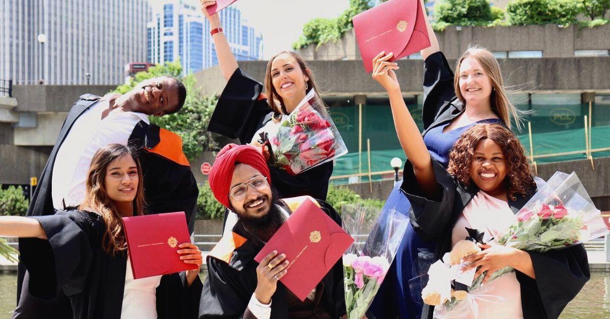 Un groupe de nouveaux diplômés près du canal Rideau, ils tiennent des diplômes et des bouquets.