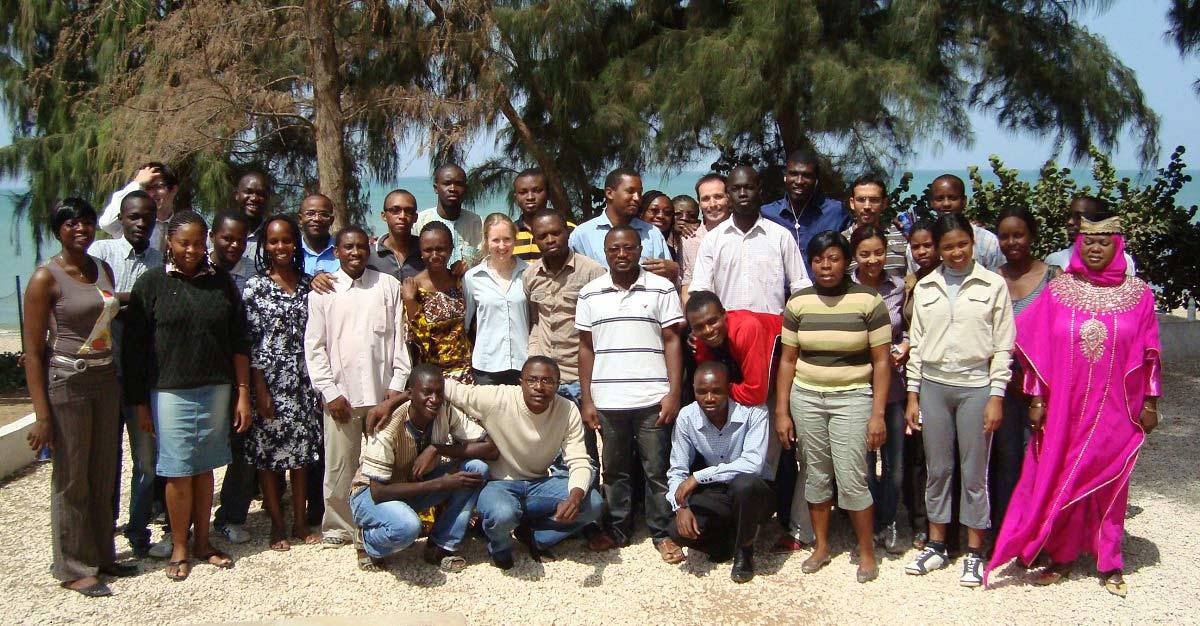 Yves Bourgault with about 30 students in a class photo taken on a beach in Senegal.